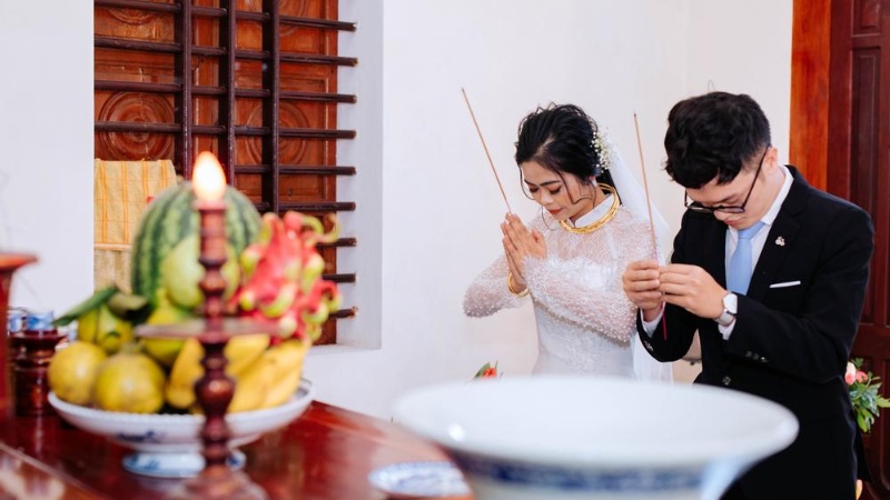 Cô dâu chú rễ thắp hương trên bàn thờ gia tiên