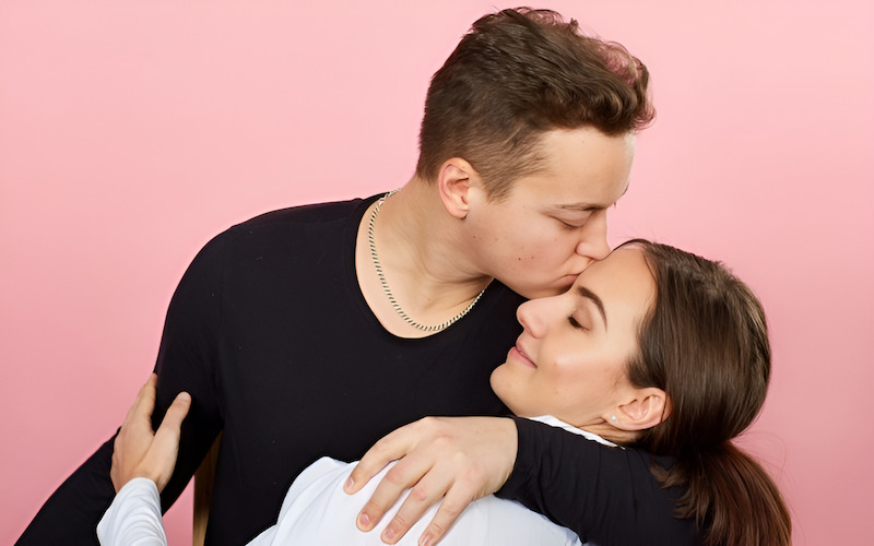 Chàng trai âu yếm hôn lên mí mắt bạn gái đang nhắm mắt tận hưởng