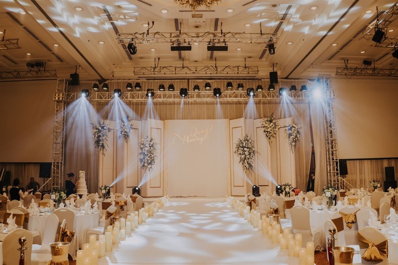 Một cặp đôi đang ký hợp đồng đặt cọc địa điểm cưới với nhân viên tư vấn.