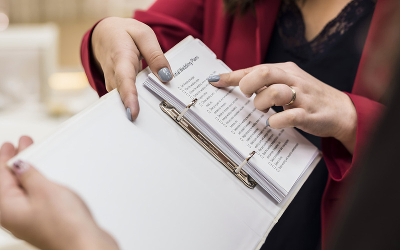 Một người đang sử dụng máy tính và ghi chép vào sổ tay để lên kế hoạch ngân sách.