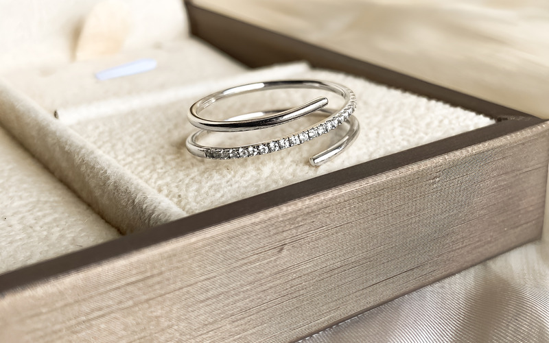 Hai bàn tay đang nhẹ nhàng điều chỉnh kích thước của một chiếc nhẫn free size.