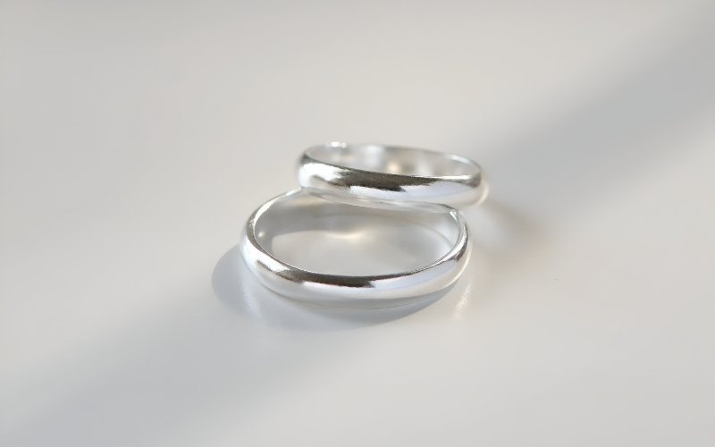 Bàn tay đang đeo nhiều chiếc nhẫn bạc có thiết kế hiện đại, tinh xảo.