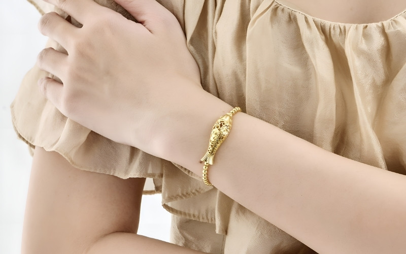 Chiếc lắc tay hay vòng tay vàng ôm lấy cổ tay nàng như một vòng tay ấm áp