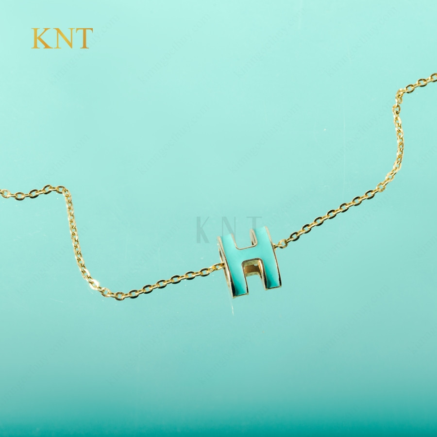 Cận cảnh mặt sứ xanh của mặt dây chuyền Sea La Vie chữ K