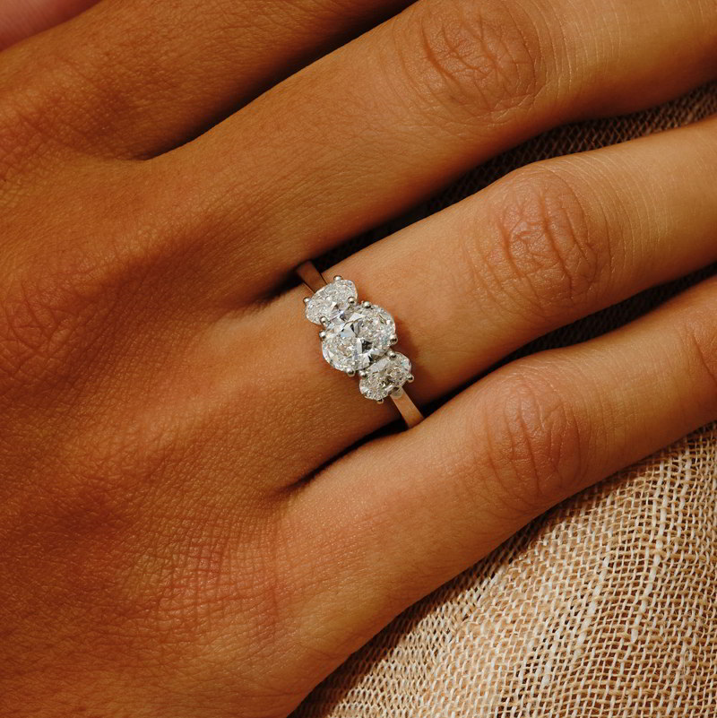 Nhẫn kim cương oval three-stone với viên chủ và hai viên đá phụ.
